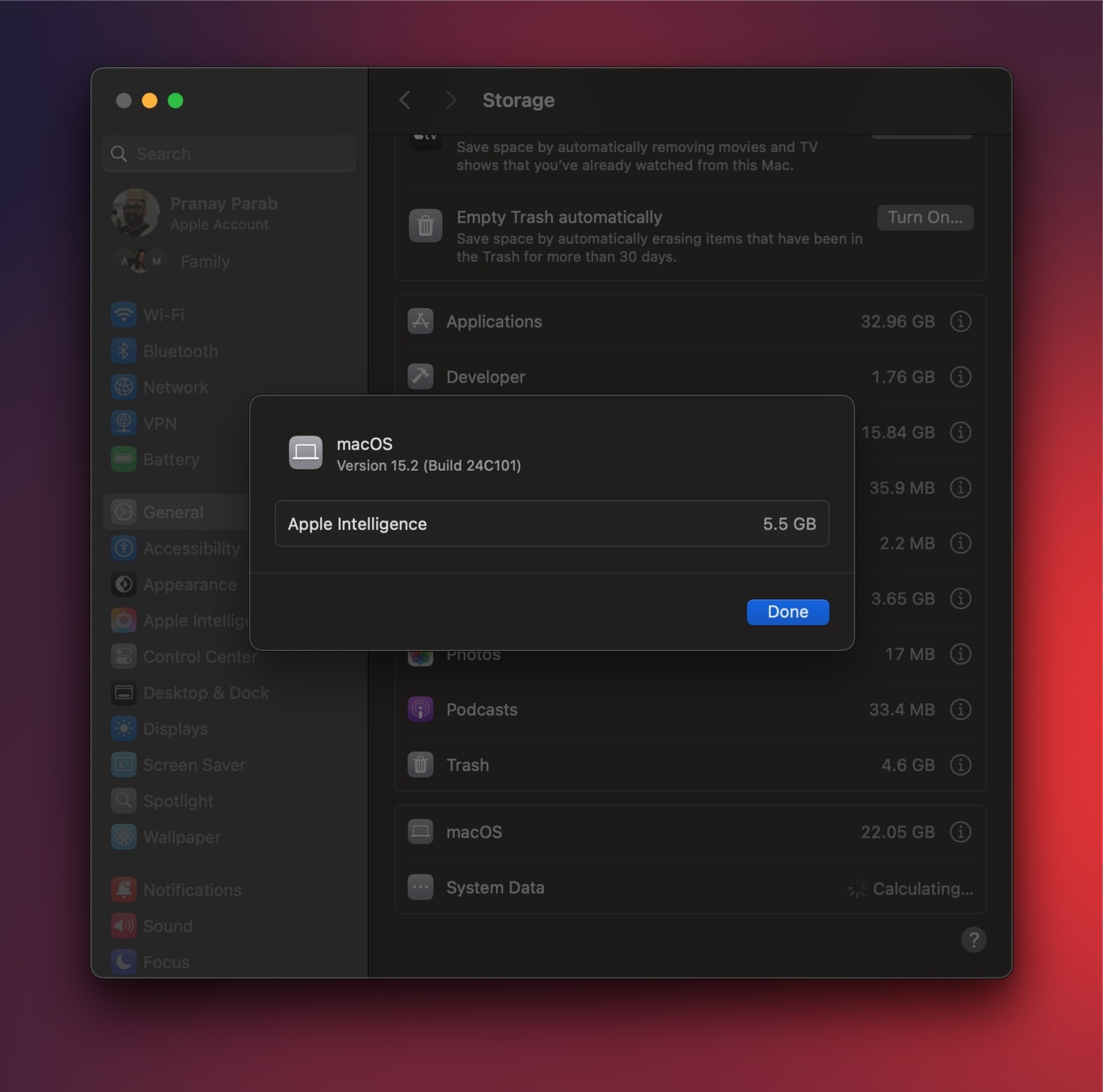L'application des réglages sur macOS avec la plupart de la fenêtre floue. L'accent est mis sur une petite fenêtre contextuelle qui indique : version macOS 15.2. Apple Intelligence 5.5 Go